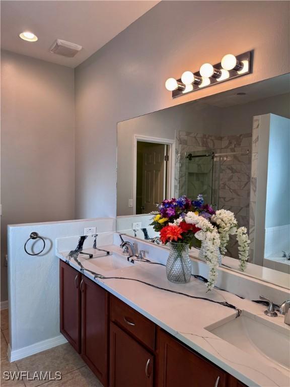 bathroom featuring vanity, tile patterned flooring, and plus walk in shower