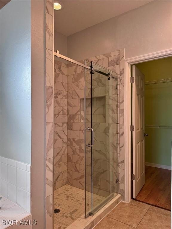 bathroom with wood-type flooring and walk in shower