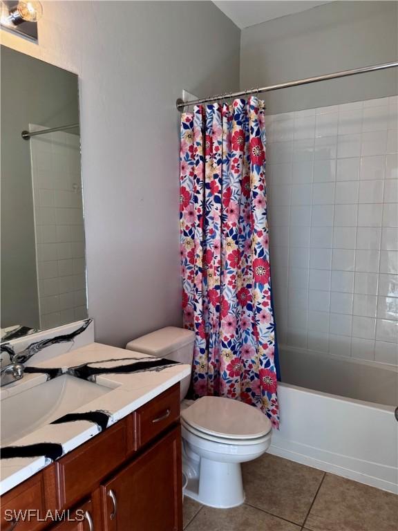 full bathroom featuring tile patterned floors, vanity, toilet, and shower / tub combo with curtain