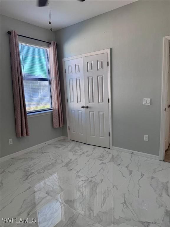 unfurnished bedroom with ceiling fan and a closet