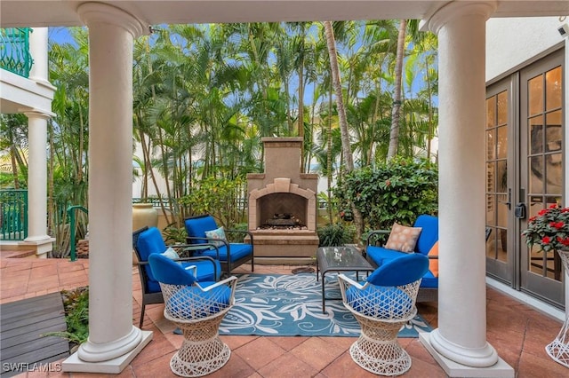 view of patio with french doors and an outdoor stone fireplace