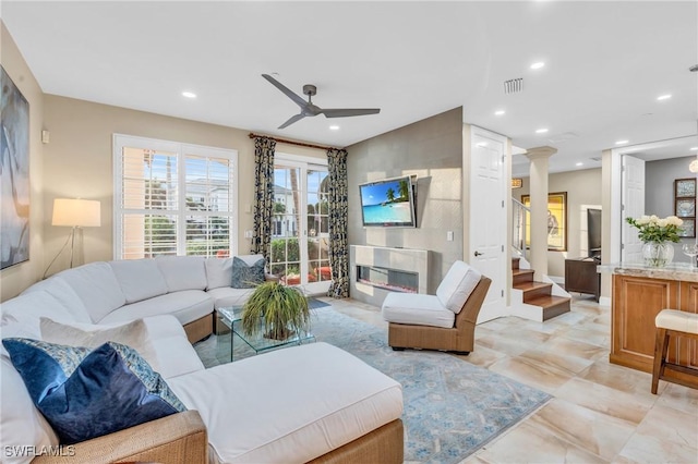 living room with ornate columns and ceiling fan