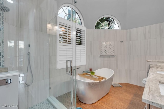 bathroom with plus walk in shower, vanity, and tile walls