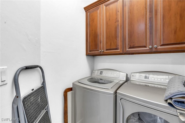 laundry room with washer and dryer and cabinets