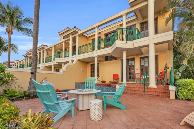 exterior space with a fire pit and a balcony