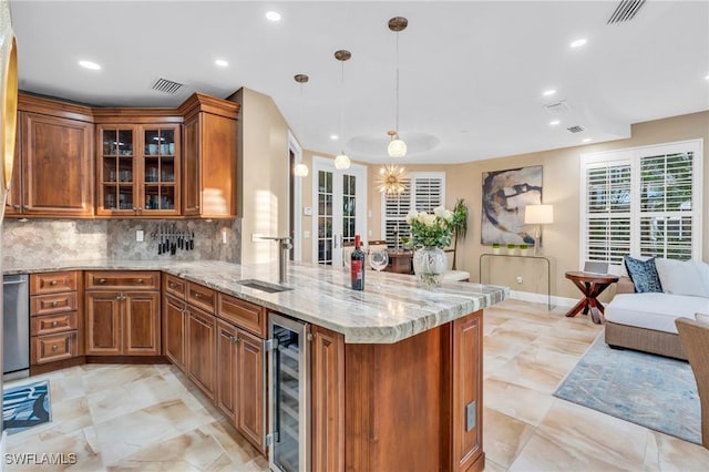 kitchen with backsplash, sink, wine cooler, decorative light fixtures, and kitchen peninsula