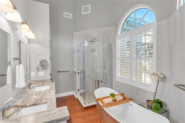 bathroom featuring hardwood / wood-style floors, vanity, and shower with separate bathtub