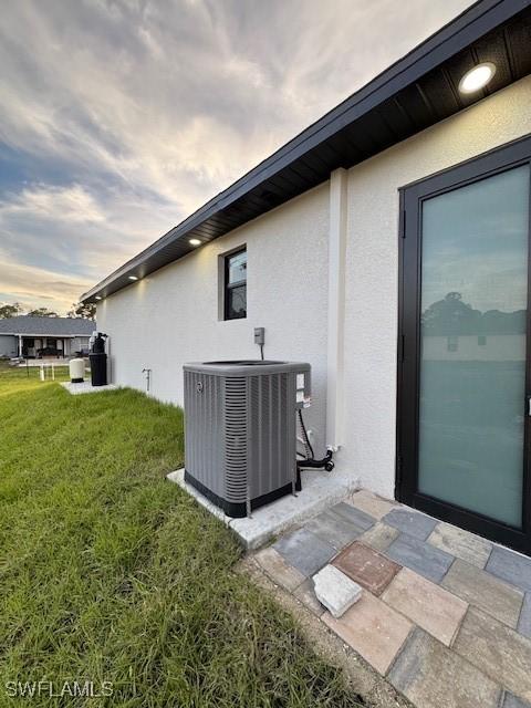 view of side of property with a yard and cooling unit