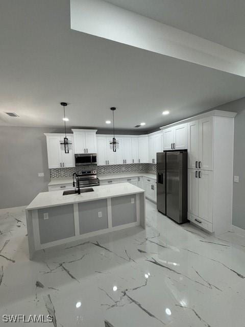 kitchen featuring sink, stainless steel appliances, backsplash, decorative light fixtures, and white cabinets