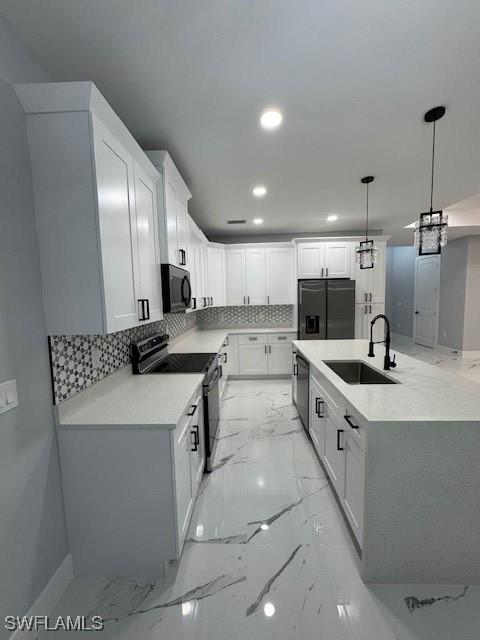 kitchen featuring backsplash, stainless steel appliances, sink, pendant lighting, and white cabinets