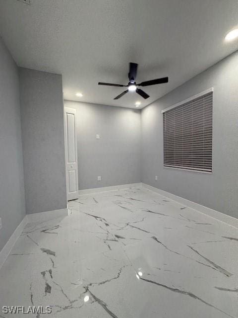 unfurnished room with ceiling fan and a textured ceiling