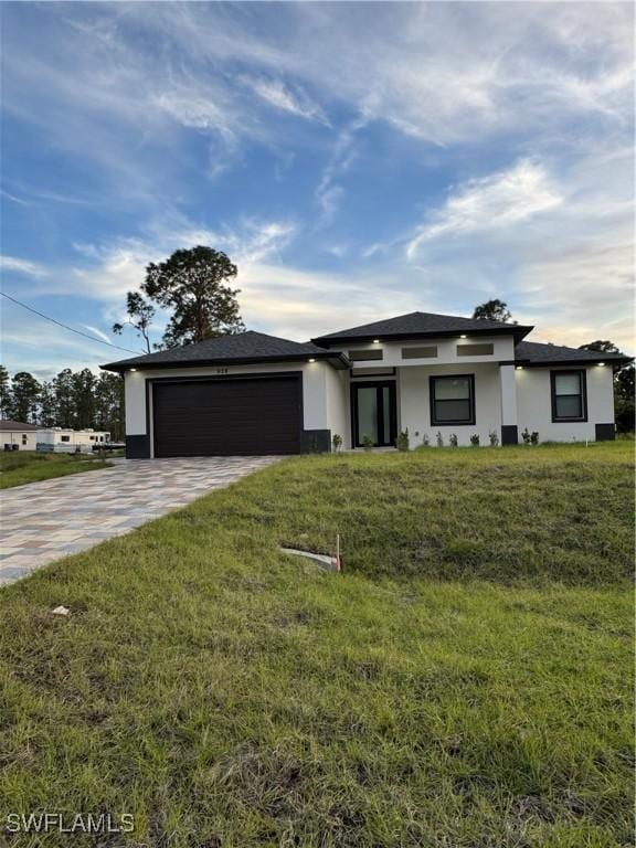 ranch-style home with a garage and a front lawn