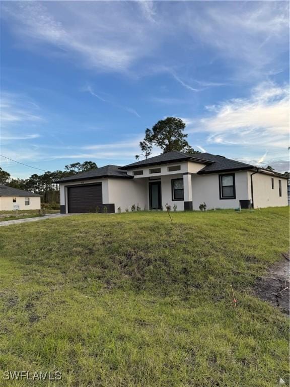 view of front of house featuring a front lawn and a garage