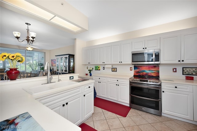 kitchen with sink, white cabinetry, hanging light fixtures, an inviting chandelier, and stainless steel appliances