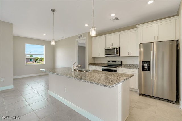 kitchen with white cabinets, stainless steel appliances, a kitchen island with sink, and sink