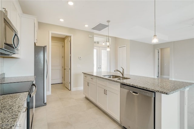 kitchen with a kitchen island with sink, sink, white cabinets, and appliances with stainless steel finishes