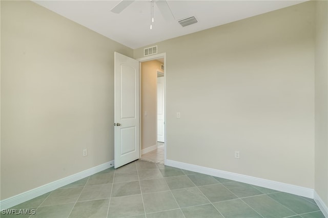 tiled empty room with ceiling fan