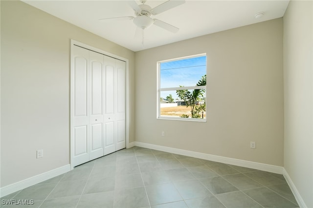 unfurnished bedroom featuring a closet, ceiling fan, and light tile patterned flooring