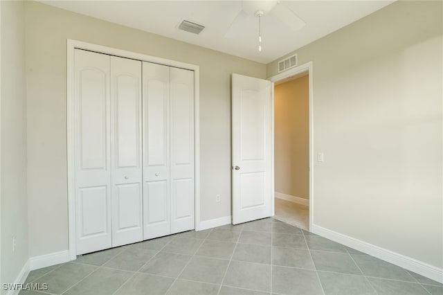 unfurnished bedroom featuring ceiling fan, a closet, and light tile patterned flooring