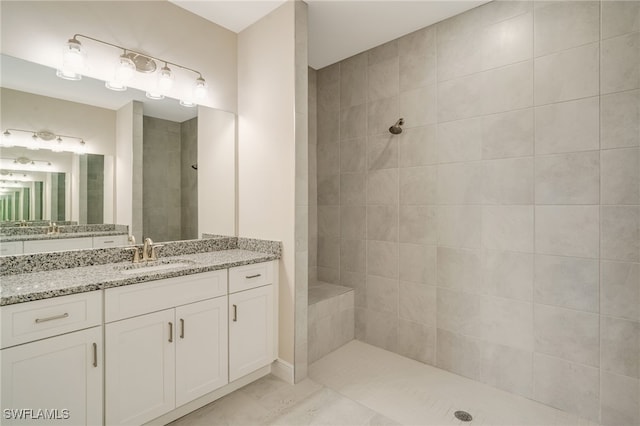 bathroom featuring a tile shower, vanity, and tile patterned floors