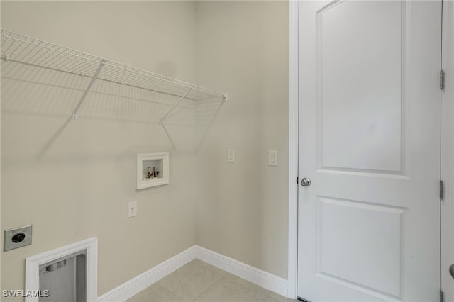 laundry area with electric dryer hookup, light tile patterned floors, and washer hookup