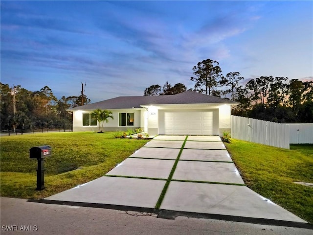 ranch-style house with a garage and a lawn