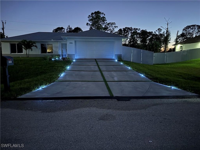 view of front of property with a garage and a lawn