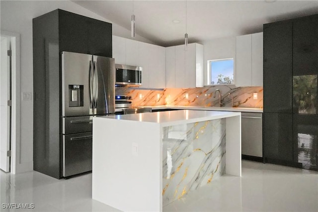 kitchen featuring white cabinets, a center island, backsplash, and appliances with stainless steel finishes