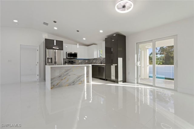 kitchen with pendant lighting, a center island, lofted ceiling, backsplash, and stainless steel appliances