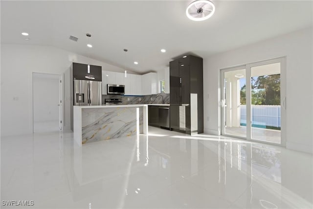 3306 E 7th St, Lehigh Acres, FL 33972 - kitchen featuring stainless steel appliances, modern cabinets, tasteful backsplash, vaulted ceiling, and light tile patterned floors