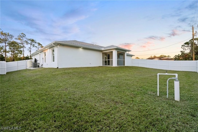 3306 E 7th St, Lehigh Acres, FL 33972 - back of house at dusk featuring stucco siding and a fenced backyard