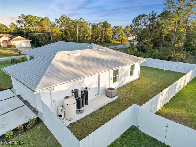 3306 E 7th St, Lehigh Acres, FL 33972 - back of property featuring a fenced backyard, roof with shingles, stucco siding, and view of wooded area