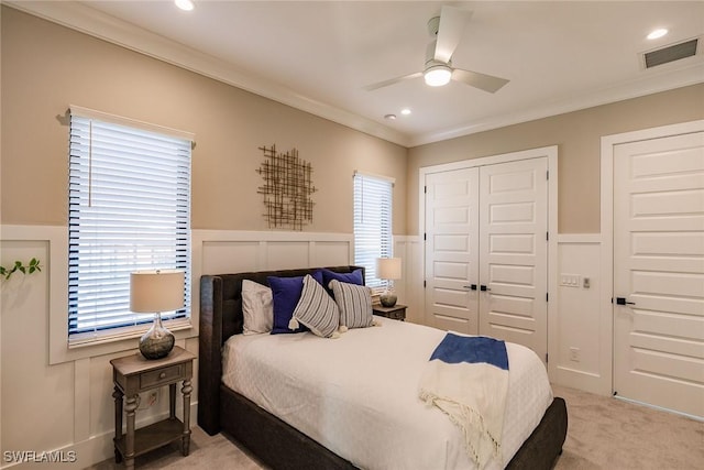 bedroom with ceiling fan, ornamental molding, and light carpet