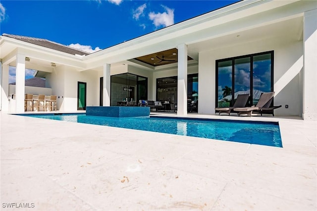 view of swimming pool featuring ceiling fan, a bar, and a patio