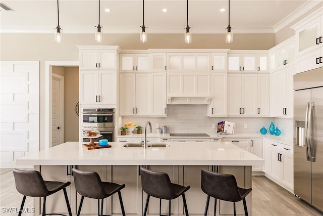 kitchen with sink, hanging light fixtures, a center island with sink, and appliances with stainless steel finishes