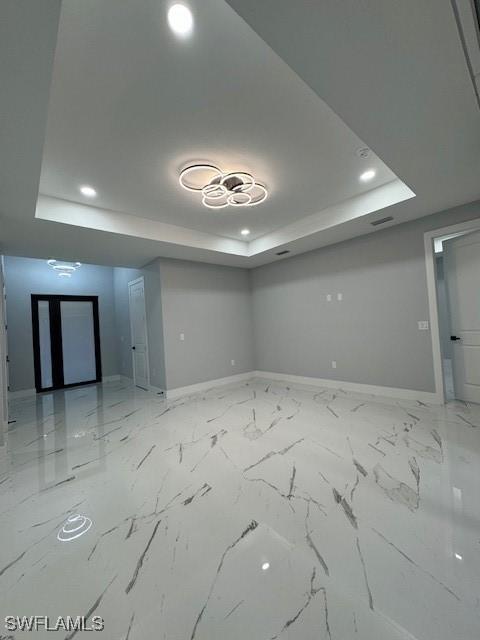 unfurnished room with a raised ceiling