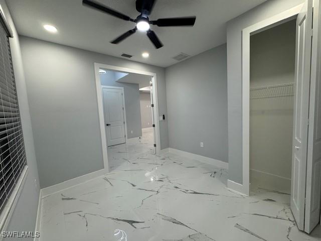 unfurnished bedroom featuring ceiling fan and a closet