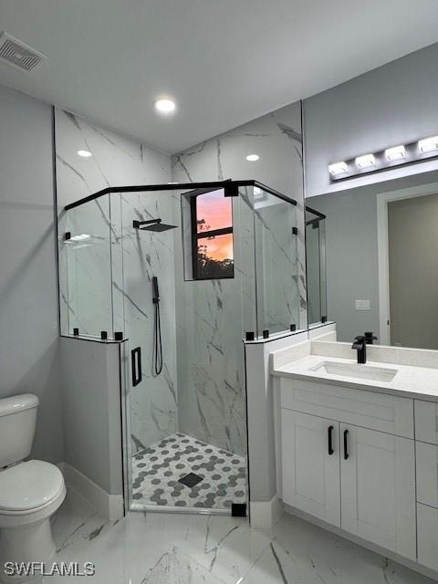 bathroom with vanity, toilet, and a shower with shower door