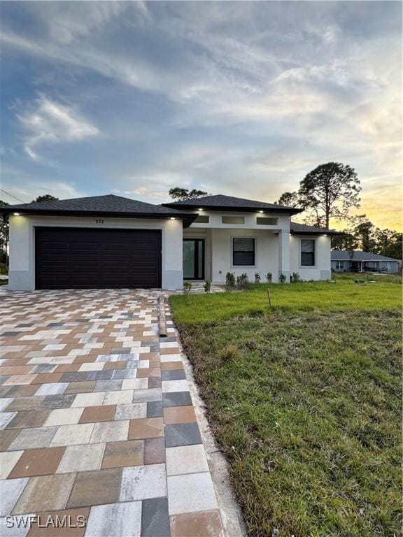 932 Milwaukee Blvd, Lehigh Acres, FL 33974 - view of front of home featuring a garage and a yard