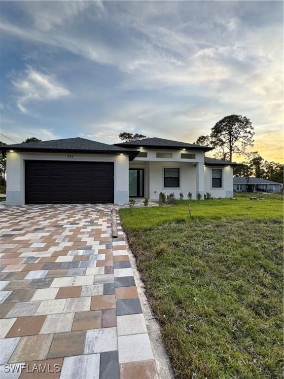 view of front of home featuring a garage and a yard