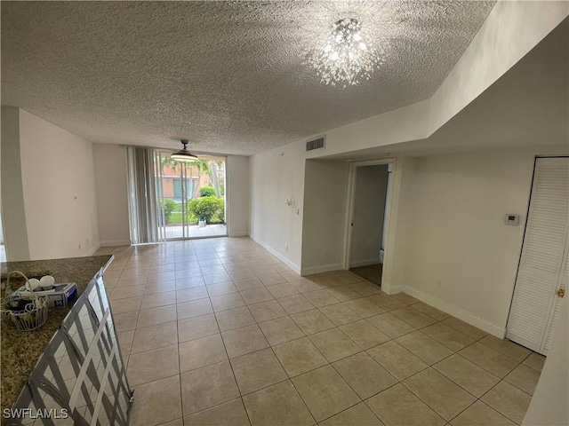 1275 Wildwood Lakes Blvd Unit 105, Naples, FL 34104 - unfurnished room with baseboards, a textured ceiling, visible vents, and light tile patterned floors