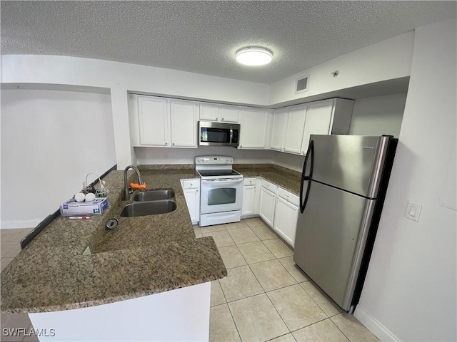 1275 Wildwood Lakes Blvd Unit 105, Naples, FL 34104 - kitchen with light tile patterned flooring, a sink, a peninsula, and appliances with stainless steel finishes