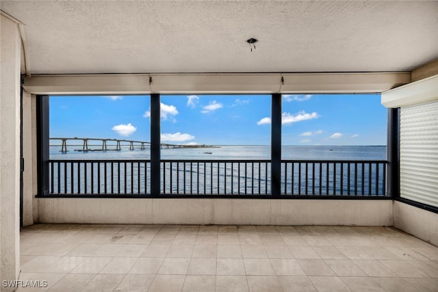 unfurnished sunroom with a water view