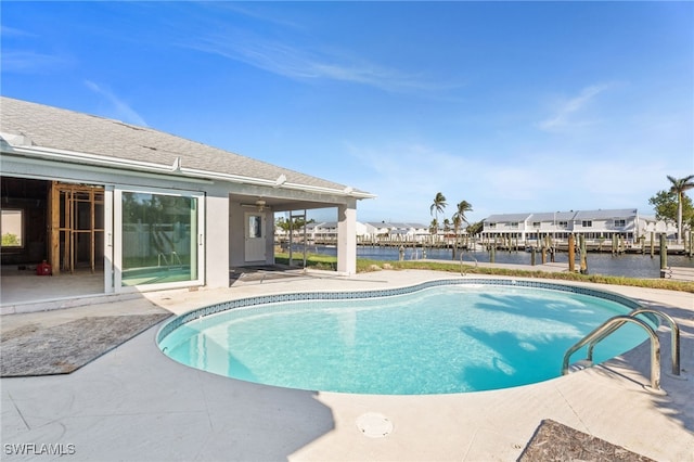 view of swimming pool featuring a water view and a patio area