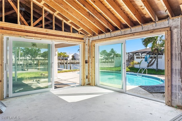 interior space featuring a water view, concrete flooring, and vaulted ceiling