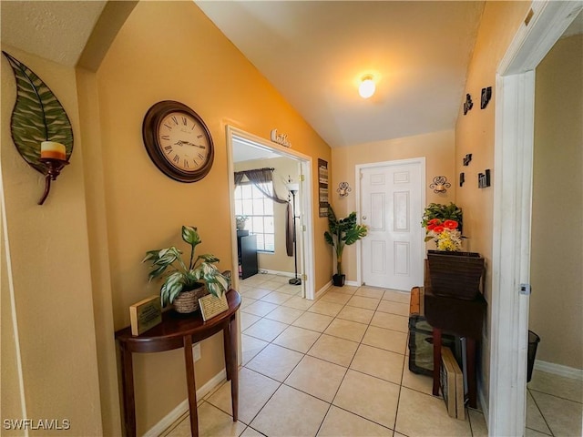 entryway featuring lofted ceiling and light tile patterned flooring