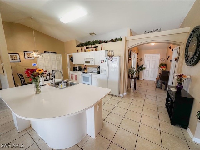 kitchen with white appliances, vaulted ceiling, a center island with sink, white cabinets, and sink