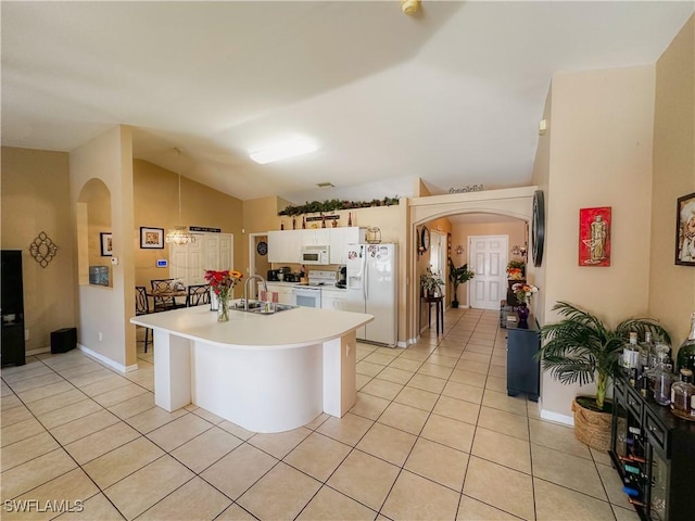 kitchen with white appliances, lofted ceiling, light tile patterned floors, and sink