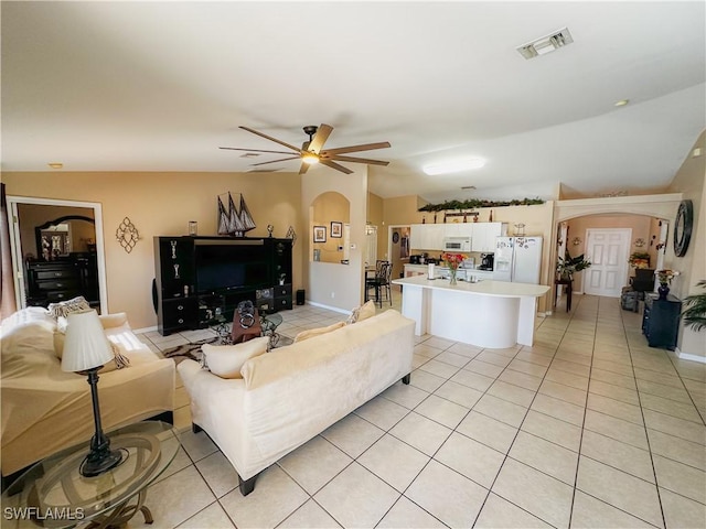 living room with ceiling fan, vaulted ceiling, and light tile patterned flooring