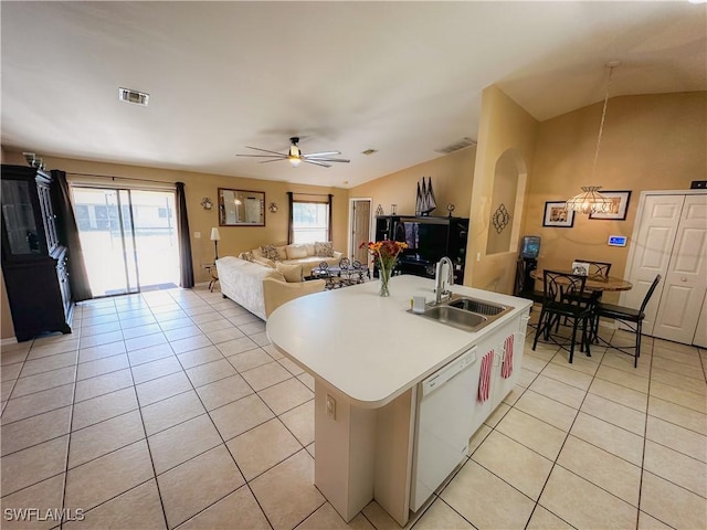 kitchen featuring sink, light tile patterned flooring, ceiling fan, white dishwasher, and a center island with sink